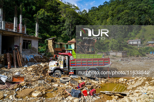 Flooding from the Salamdo River sweeps and damages a vehicle in Patikharka, Kavrepalanchok District, Nepal, on October 3, 2024. 