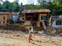 A child walks in front of her home damaged by flooding from the Salamdo River in Patikharka, Kavrepalanchok District, Nepal, on October 3, 2...