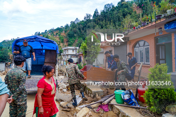 People move to a safe area away from damaged homes in Patikharka, Kavrepalanchok District, Nepal, on October 3, 2024. Homes are severely dam...