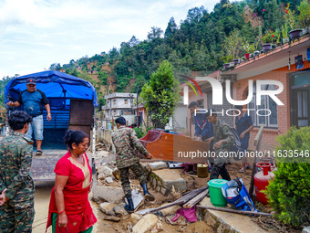 People move to a safe area away from damaged homes in Patikharka, Kavrepalanchok District, Nepal, on October 3, 2024. Homes are severely dam...