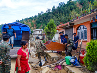 People move to a safe area away from damaged homes in Patikharka, Kavrepalanchok District, Nepal, on October 3, 2024. Homes are severely dam...