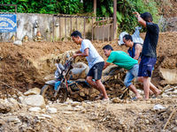 People pull a flood-damaged bike from the Salamdo River in Patikharka, Kavrepalanchok District, Nepal, on October 3, 2024. (