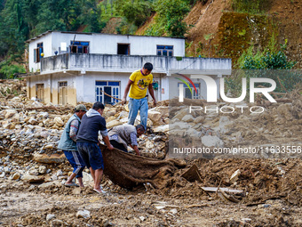 People search for their belongings in damaged houses due to Salamdo River flooding in Patikharka of Kavrepalanchok District, Nepal, on Octob...