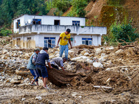 People search for their belongings in damaged houses due to Salamdo River flooding in Patikharka of Kavrepalanchok District, Nepal, on Octob...