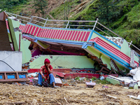 A woman sits in front of her flood-damaged home from the Salamdo River in Patikharka, Kavrepalanchok District, Nepal, on October 03, 2024. A...