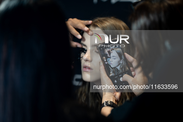 Someone takes a photo of a model with a mobile phone backstage before she walks on the runway during Day 2 of Bangkok International Fashion...