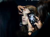 Someone takes a photo of a model with a mobile phone backstage before she walks on the runway during Day 2 of Bangkok International Fashion...