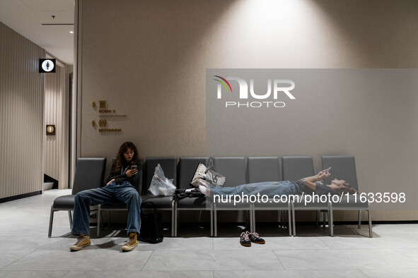 Models take a break backstage before walking on the runway during Day 2 of Bangkok International Fashion Week at Siam Paragon in Bangkok, Th...