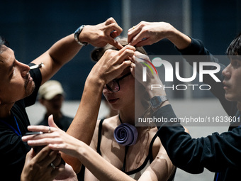 Models get ready backstage before walking on the runway during Day 2 of Bangkok International Fashion Week at Siam Paragon in Bangkok, Thail...