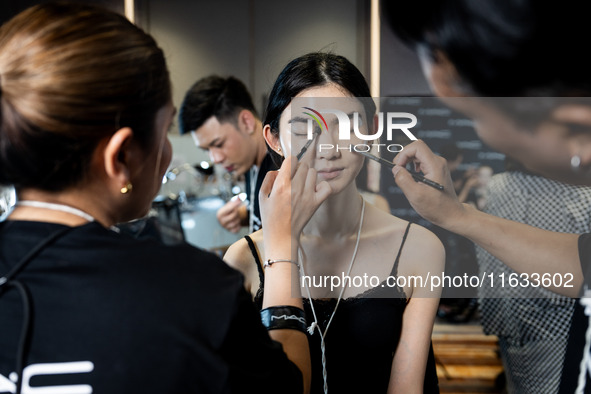 Models get ready backstage before walking on the runway during Day 2 of Bangkok International Fashion Week at Siam Paragon in Bangkok, Thail...