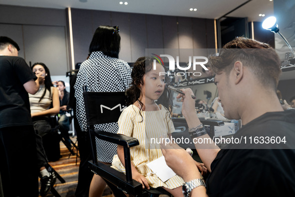 Linda, a young Thai twin, gets ready backstage before walking on the runway during Day 2 of Bangkok International Fashion Week at Siam Parag...