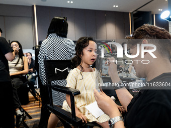 Linda, a young Thai twin, gets ready backstage before walking on the runway during Day 2 of Bangkok International Fashion Week at Siam Parag...