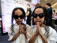 Young twin models give a 'Wai' greeting on the red carpet after walking on the runway during Day 2 of Bangkok International Fashion Week at...