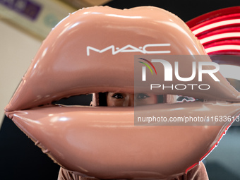 A representative of MAC cosmetics dresses up as a set of lips during Day 2 of Bangkok International Fashion Week at Siam Paragon in Bangkok,...