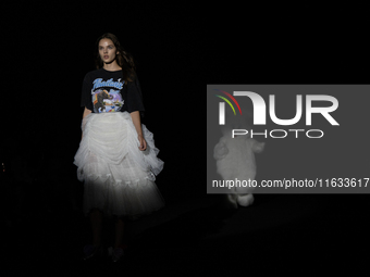 A model showcases a creation by TandT and runs from a giant rabbit on the runway during Day 2 of Bangkok International Fashion Week at Siam...