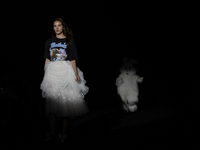 A model showcases a creation by TandT and runs from a giant rabbit on the runway during Day 2 of Bangkok International Fashion Week at Siam...