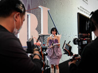 A host conducts a live broadcast outside of the runway during Day 2 of Bangkok International Fashion Week at Siam Paragon in Bangkok, Thaila...