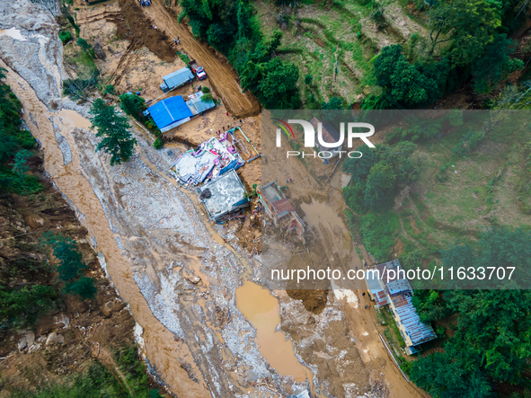 The aerial view shows the flood-affected areas of Patikharka, Kavrepalanchok District, Nepal, on October 3, 2024. Homes are severely damaged...