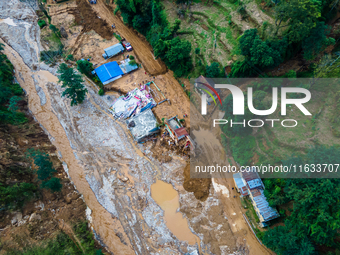 The aerial view shows the flood-affected areas of Patikharka, Kavrepalanchok District, Nepal, on October 3, 2024. Homes are severely damaged...