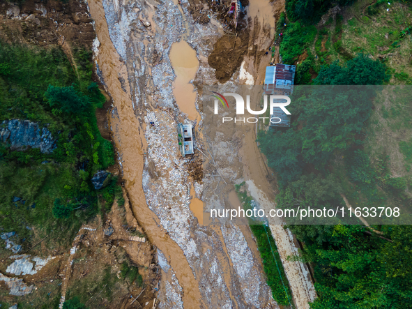 The aerial view shows the flood-affected areas of Patikharka, Kavrepalanchok District, Nepal, on October 3, 2024. Homes are severely damaged...