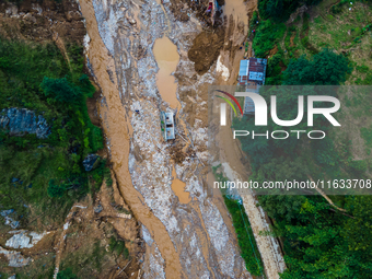 The aerial view shows the flood-affected areas of Patikharka, Kavrepalanchok District, Nepal, on October 3, 2024. Homes are severely damaged...