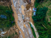 The aerial view shows the flood-affected areas of Patikharka, Kavrepalanchok District, Nepal, on October 3, 2024. Homes are severely damaged...