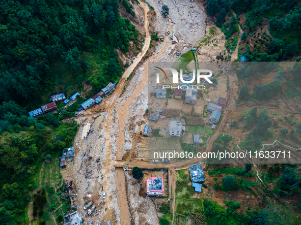 The aerial view shows the flood-affected areas of Patikharka, Kavrepalanchok District, Nepal, on October 3, 2024. Homes are severely damaged...