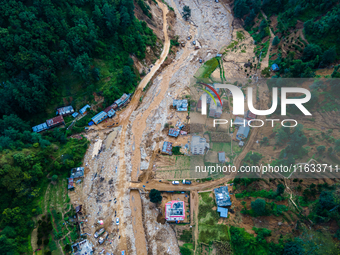 The aerial view shows the flood-affected areas of Patikharka, Kavrepalanchok District, Nepal, on October 3, 2024. Homes are severely damaged...