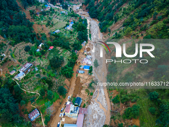 The aerial view shows the flood-affected areas of Patikharka, Kavrepalanchok District, Nepal, on October 3, 2024. Homes are severely damaged...