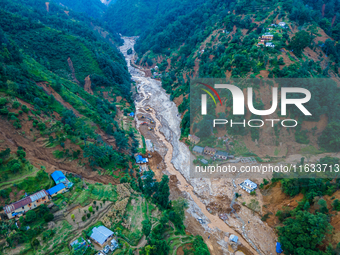 The aerial view shows the flood-affected areas of Patikharka, Kavrepalanchok District, Nepal, on October 3, 2024. Homes are severely damaged...