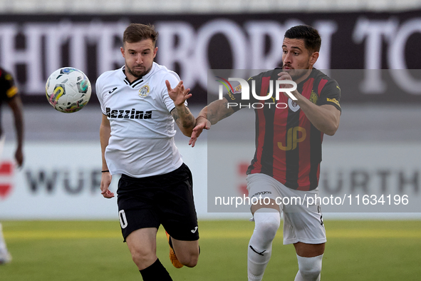 In Ta' Qali, Malta, on October 2, 2024, Jurgen Degabriele of Hibernians is closely challenged by Juan Carlos Corbalan of Hamrun Spartans dur...