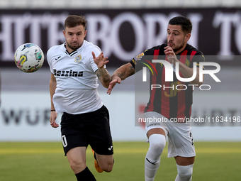 In Ta' Qali, Malta, on October 2, 2024, Jurgen Degabriele of Hibernians is closely challenged by Juan Carlos Corbalan of Hamrun Spartans dur...