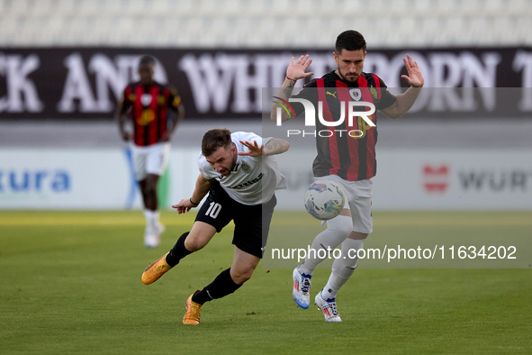 In Ta' Qali, Malta, on October 2, 2024, Jurgen Degabriele of Hibernians is closely challenged by Juan Carlos Corbalan of Hamrun Spartans dur...