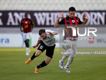 In Ta' Qali, Malta, on October 2, 2024, Jurgen Degabriele of Hibernians is closely challenged by Juan Carlos Corbalan of Hamrun Spartans dur...