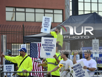 Longshoremen carry placards and demonstrate in front of the Red Hook terminal in Brooklyn, New York, U.S., on October 3, 2024. Longshoremen...