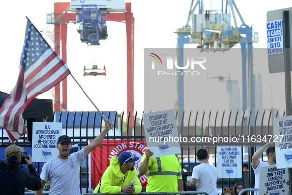 Longshoremen carry placards and demonstrate in front of the Red Hook terminal in Brooklyn, New York, U.S., on October 3, 2024. Longshoremen...