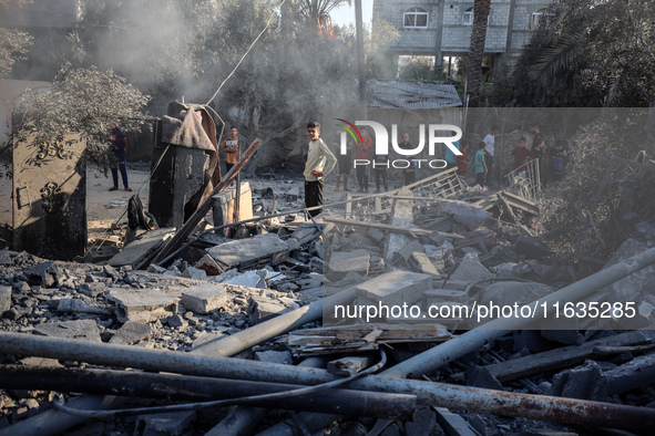 Palestinians inspect a house damaged in an Israeli airstrike in Deir al-Balah, central Gaza Strip, on October 4, 2024, amid the ongoing war...