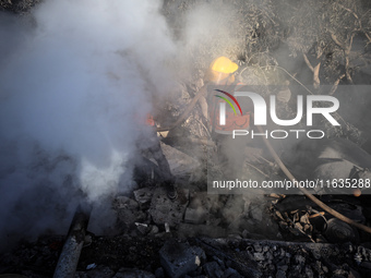 Palestinian Civil Defense rescuers attempt to extinguish fires following an Israeli airstrike in Deir al-Balah, central Gaza Strip, on Octob...