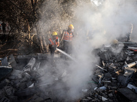 Palestinian Civil Defense rescuers attempt to extinguish fires following an Israeli airstrike in Deir al-Balah, central Gaza Strip, on Octob...