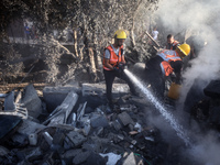 Palestinian Civil Defense rescuers attempt to extinguish fires following an Israeli airstrike in Deir al-Balah, central Gaza Strip, on Octob...