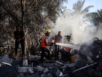 Palestinian Civil Defense rescuers attempt to extinguish fires following an Israeli airstrike in Deir al-Balah, central Gaza Strip, on Octob...