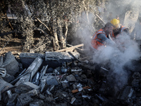 Palestinian Civil Defense rescuers attempt to extinguish fires following an Israeli airstrike in Deir al-Balah, central Gaza Strip, on Octob...