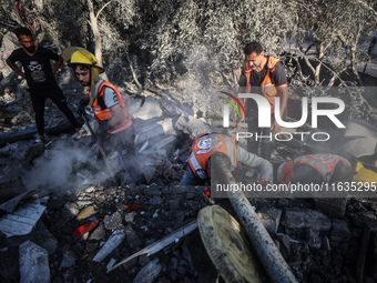 Palestinian Civil Defense rescuers attempt to extinguish fires following an Israeli airstrike in Deir al-Balah, central Gaza Strip, on Octob...