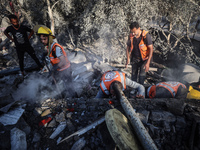 Palestinian Civil Defense rescuers attempt to extinguish fires following an Israeli airstrike in Deir al-Balah, central Gaza Strip, on Octob...