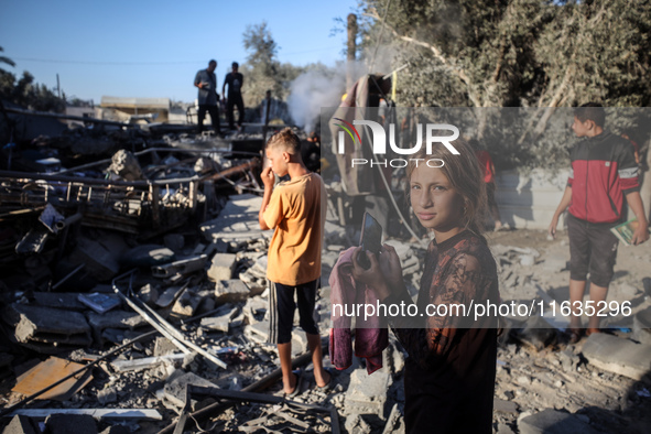 Palestinians inspect a house damaged in an Israeli airstrike in Deir al-Balah, central Gaza Strip, on October 4, 2024, amid the ongoing war...