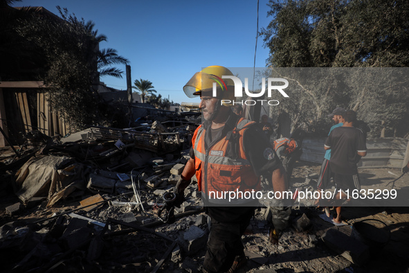 Palestinian Civil Defense rescuers attempt to extinguish fires following an Israeli airstrike in Deir al-Balah, central Gaza Strip, on Octob...