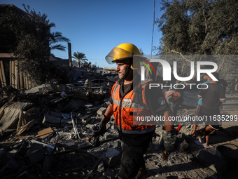 Palestinian Civil Defense rescuers attempt to extinguish fires following an Israeli airstrike in Deir al-Balah, central Gaza Strip, on Octob...