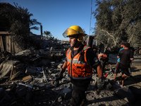 Palestinian Civil Defense rescuers attempt to extinguish fires following an Israeli airstrike in Deir al-Balah, central Gaza Strip, on Octob...