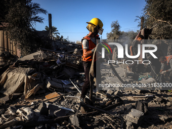 Palestinian Civil Defense rescuers attempt to extinguish fires following an Israeli airstrike in Deir al-Balah, central Gaza Strip, on Octob...