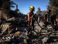 Palestinian Civil Defense rescuers attempt to extinguish fires following an Israeli airstrike in Deir al-Balah, central Gaza Strip, on Octob...